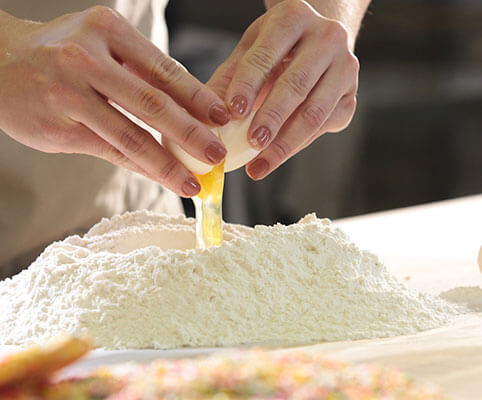 cracking egg into flour