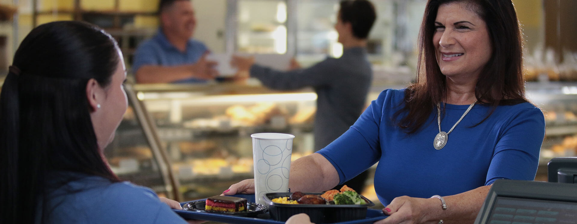 Employee handing tray of food to customer